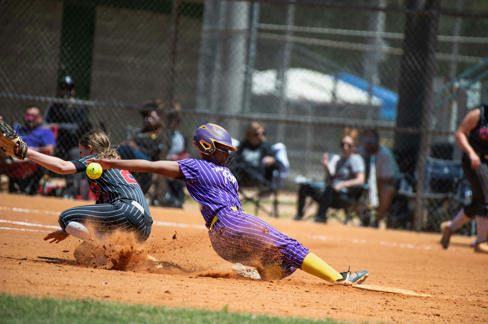 Softball player sliding into a base.