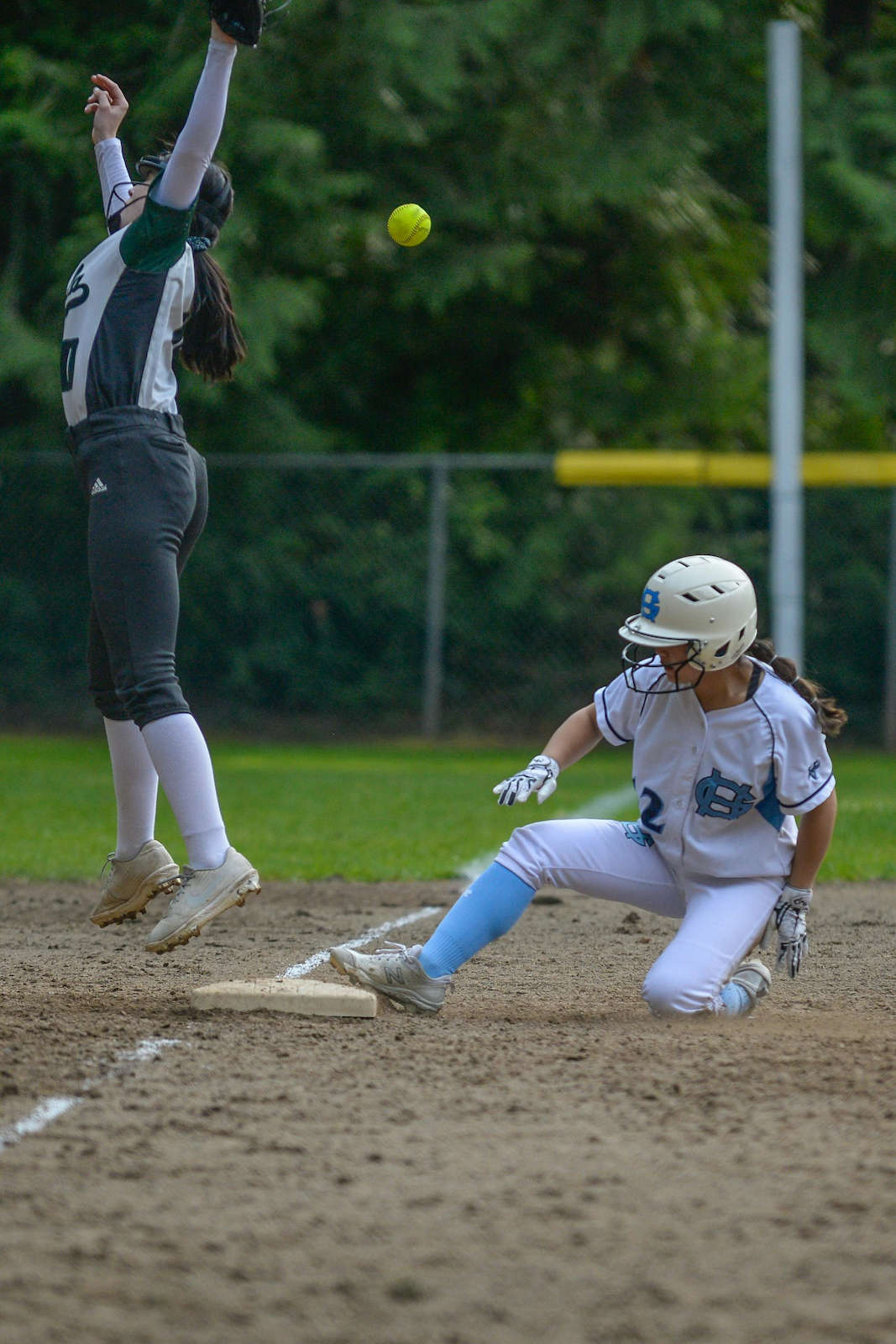 Softball player slides into base.
